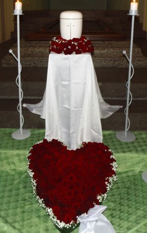 Blumenschmuck aus roten Rosenblüten für eine Urnenbeisetzung Blumenschmuck aus roten Rosenblüten für eine Urnenbeisetzung